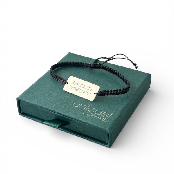 Pulsera coordenadas plata personalizada en la muñeca de una persona, mostrando las coordenadas grabadas.