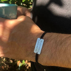 Pulsera coordenadas plata personalizada en la muñeca de una persona, mostrando las coordenadas grabadas.